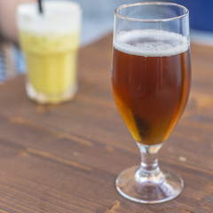 Blond beer on a glass close up on a wooden table