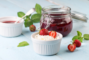 Cottage cheese and strawberry jam in a jar on wooden background