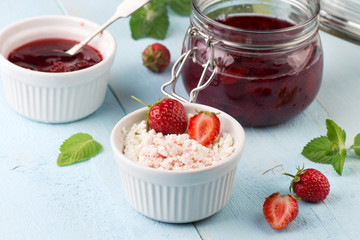Cottage cheese and strawberry jam in a jar on wooden background