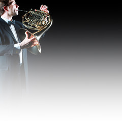 French horn player with instrument