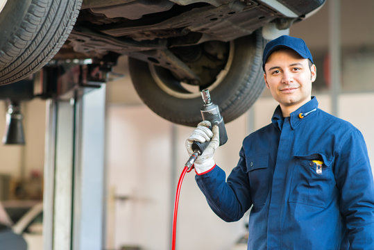 Portrait of a mechanic replacing a wheel