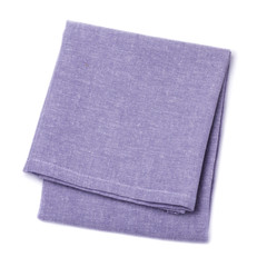 Folded napkins violet color on white background, top view