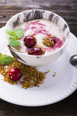 Smoothie bowl topped with cherry, bee pollen