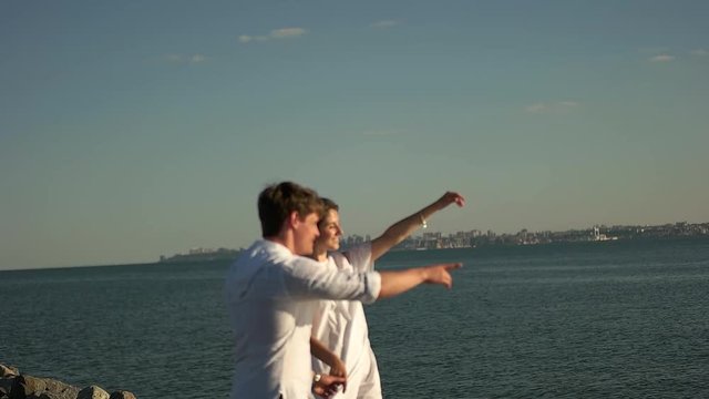 Couple walking on the beach holding hands.