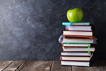 Books and apple in front of chalk board