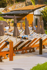 Fototapeta na wymiar Luxury beachfront complex with sun loungers and umbrellas on the Adriatic coast. Dubrovnik, Croatia.