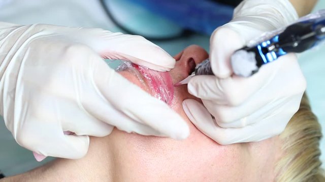 Lip tattoo woman in a beauty salon process