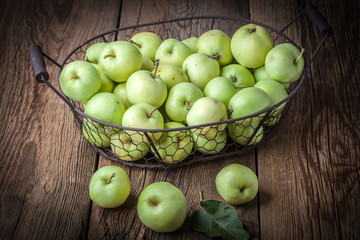 Green apples in a metal basket.