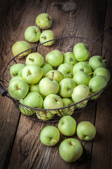 Green apples in a metal basket.