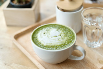 Hot green tea set on a wooden table in a coffeshop