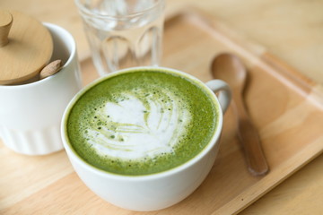 Hot green tea set on a wooden table in a coffeshop