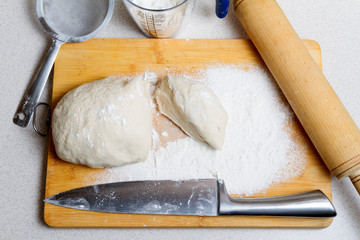 Raw dough on a cutting board, cut into two parts