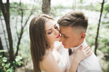 Wedding couple man, bride kissing and hugging on a background of the river, mountains. Beauty portrait