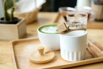 Naklejka na ściany i meble Hot green tea set on a wooden table in a coffeshop