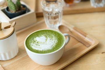 Hot green tea set on a wooden table in a coffeshop
