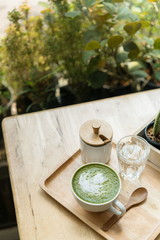 Hot green tea set on a wooden table in a coffeshop