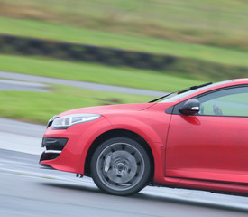 Fototapeta na wymiar Red road car zooming around a race track