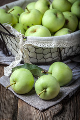 Green apples in a metal basket.