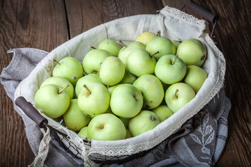 Green apples in a metal basket.