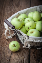 Green apples in a metal basket.