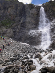 Toned image of a group of people to climb up the mountain in the background of a beautiful waterfall