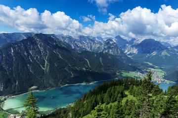 Fototapeta na wymiar Aerial view of blue mountain lake between forested rocky mountains. Achensee, Austria, Tyrol