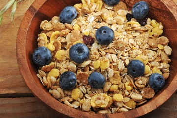 healthy Breakfast - cereal with blueberries in a wooden bowl