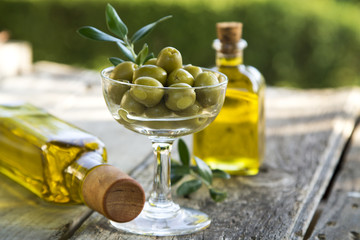 glass cup full of olives with green background © tetxu