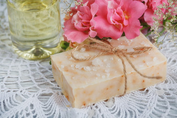 Obraz na płótnie Canvas Natural handmade soap, aromatic oil and flowers on white wooden