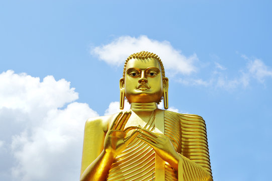 Golden Buddha on a background of clear sky.