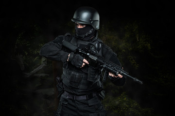 Spec ops police officer SWAT in black uniform and face mask - obrazy, fototapety, plakaty