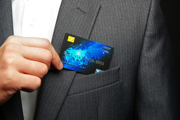 Man putting credit card in suit pocket