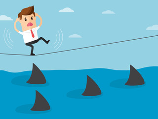 Obraz premium business man trying to walk on rope over a sea of sharks