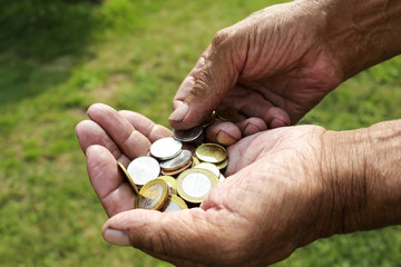 The concept of saving money.The hands of men an elderly man holding money, coins , growing business.