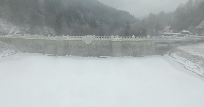 Aerial: The reservoir and bridge of Spindler Mill, Czech Republic in winter