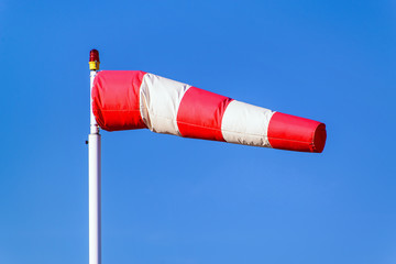 Airport windsock on clear blue sky background in windy weather indicate the local wind direction (also called: air sock, drogue, wind sleeve, wind cone)