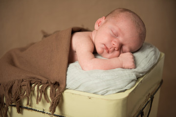 Newborn baby sleeping in a bucket. Close-up