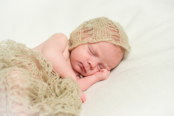 Newborn baby sleeping with hand under his cheek. Close-up