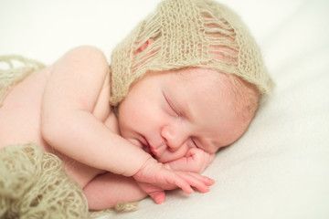 Newborn baby sleeping with hand under his cheek. Close-up