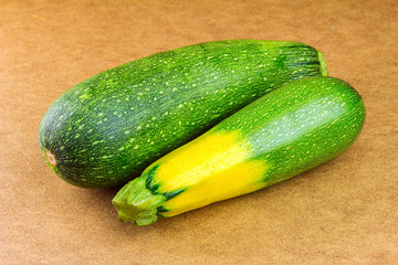 Backyard vegetables, two ripe zucchini on wooden background.