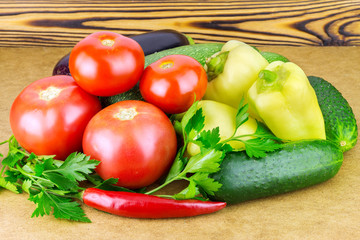 Group of fresh backyard vegetables and parsley on wooden background.