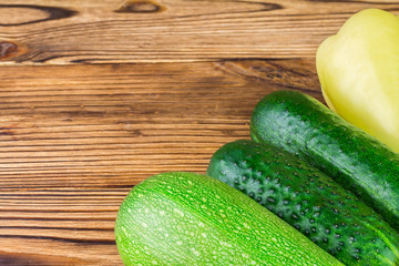 Backyard vegetables, cucumber, pepper, zucchini on wooden background.