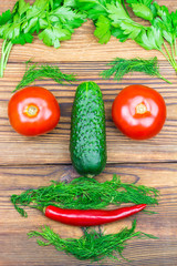 Backyard vegetables, tomatoes, cucumber, chilli pepper and herbs in the shape of men head on wooden background