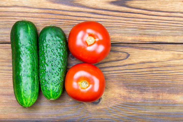 Backyard vegetables, tomatoes and cucumber on wooden background