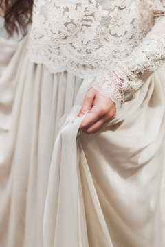 Female hand holding a delicate light silk dress