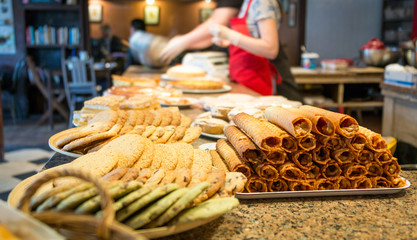 different types of sweet pastries on plates at counter cafe