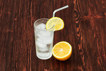 Glass of fresh lemonade with ice, cocktail on wooden background