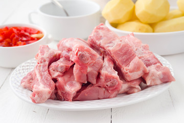 rib pork sliced and peeled potatoes in earthenware