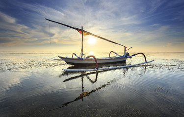 Fototapeta na wymiar Fishing boats populate the shoreline at the Sanur Beach, bali, indonesia