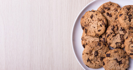 top view of chocolate cookies on white plate and copy space on w